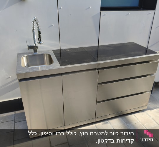 כיור נירוסטה עם ברז על משטח חיצוני